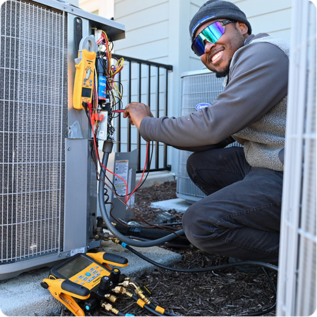 Maintenance being performed by an HVAC technician to an AC unit